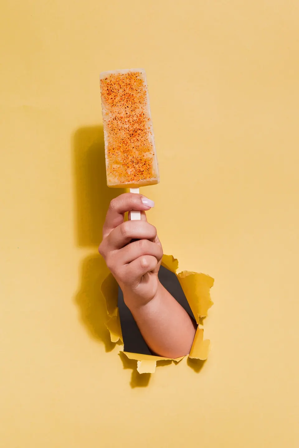 Paleta frutal IKE nivel La Tranqui con un topping ácido, sobre fondo amarillo